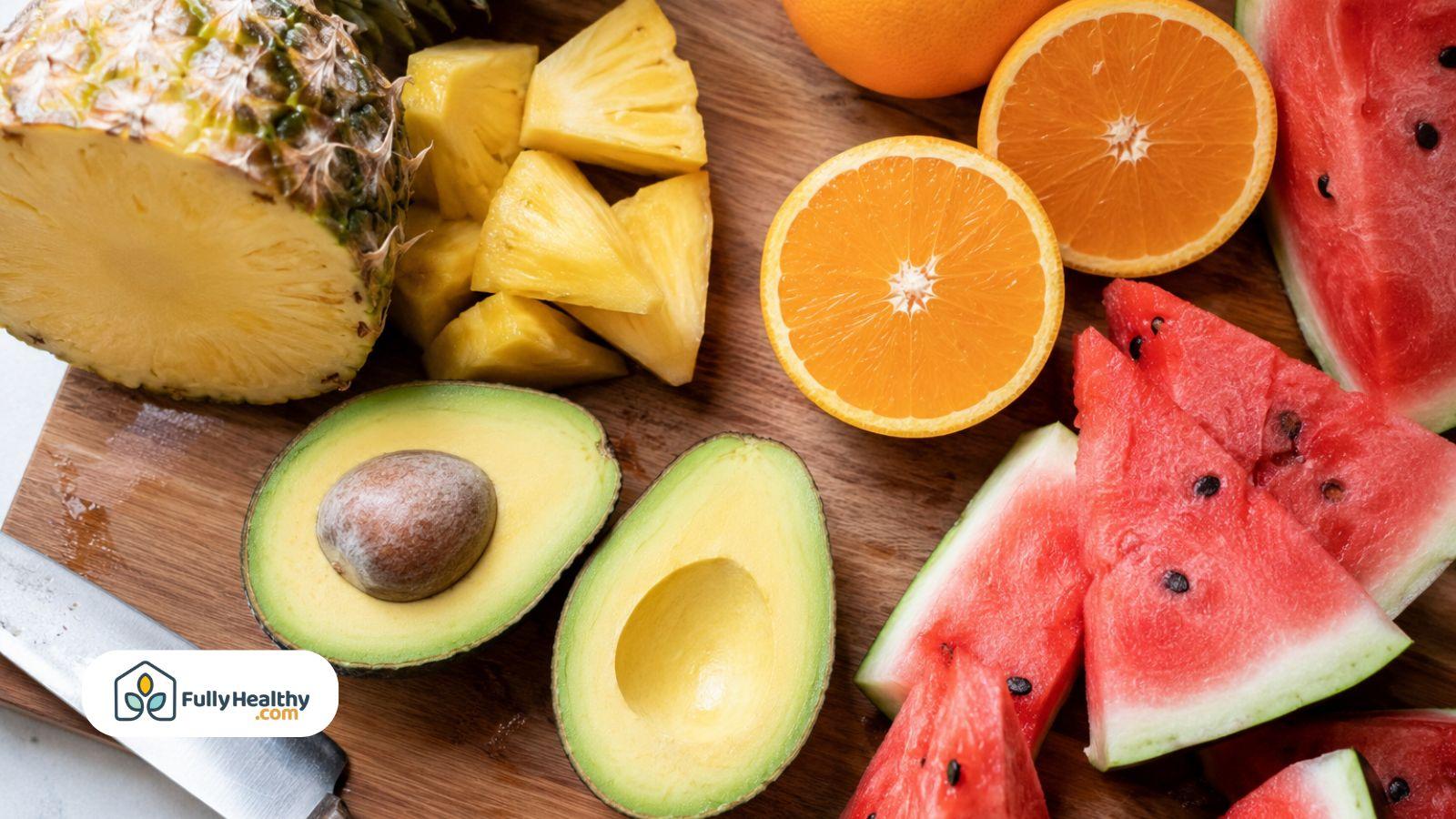 Fresh avocado beside pineapple oranges and watermelon.
