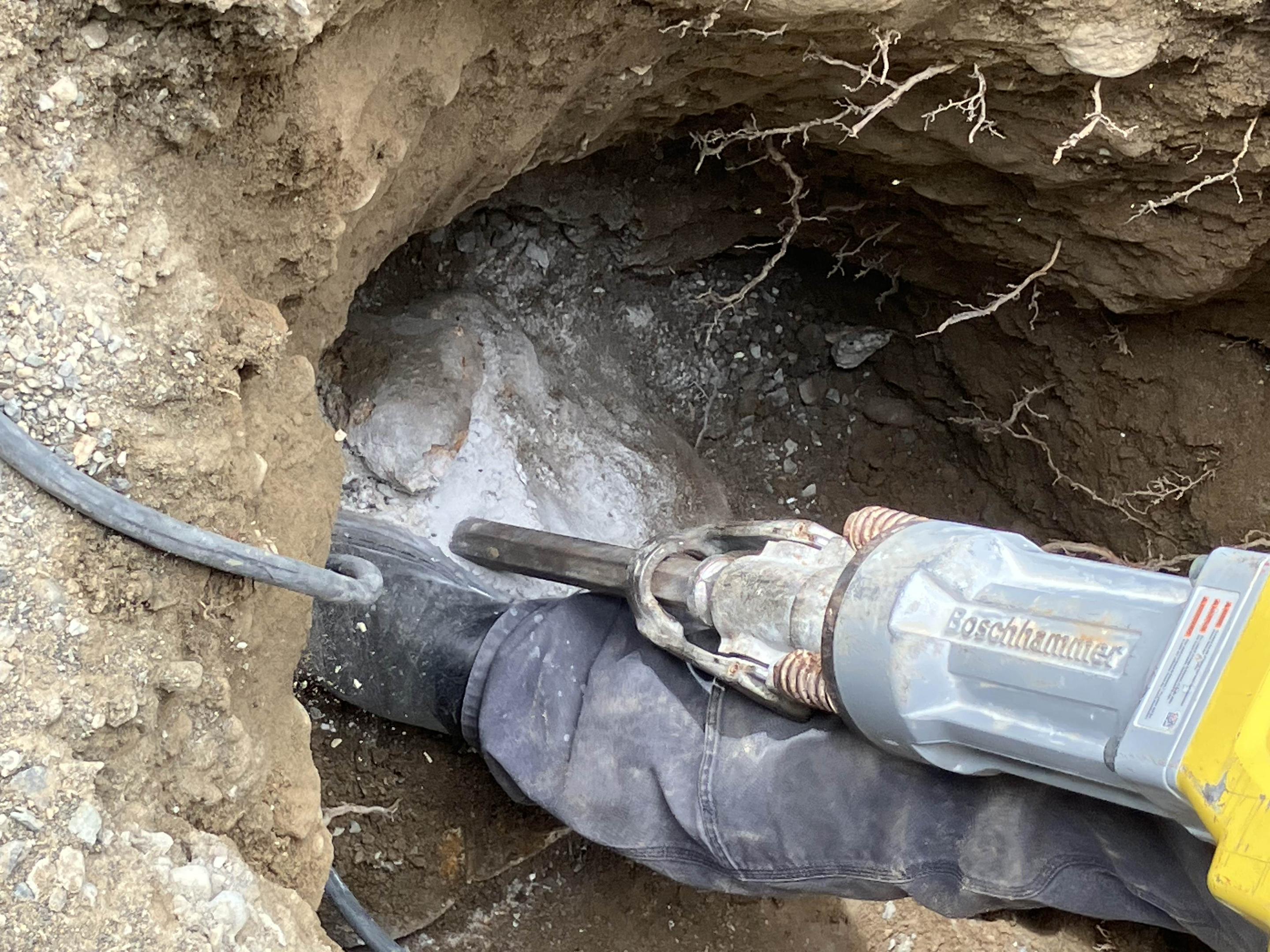 A licensed plumber in a clean uniform is inspecting plumbing pipes under a residential kitchen sink, ensuring there are no leaks and assessing the condition of the piping. This professional is ready to provide homeowners with a free plumbing estimate for any necessary repairs or plumbing projects.