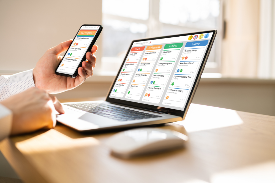 Digital marketing project management board displayed on laptop and smartphone for campaign tracking