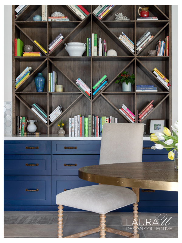 Custom geometric wood bookshelf displaying cookbooks above navy blue built-in cabinetry in a Houston kitchen.