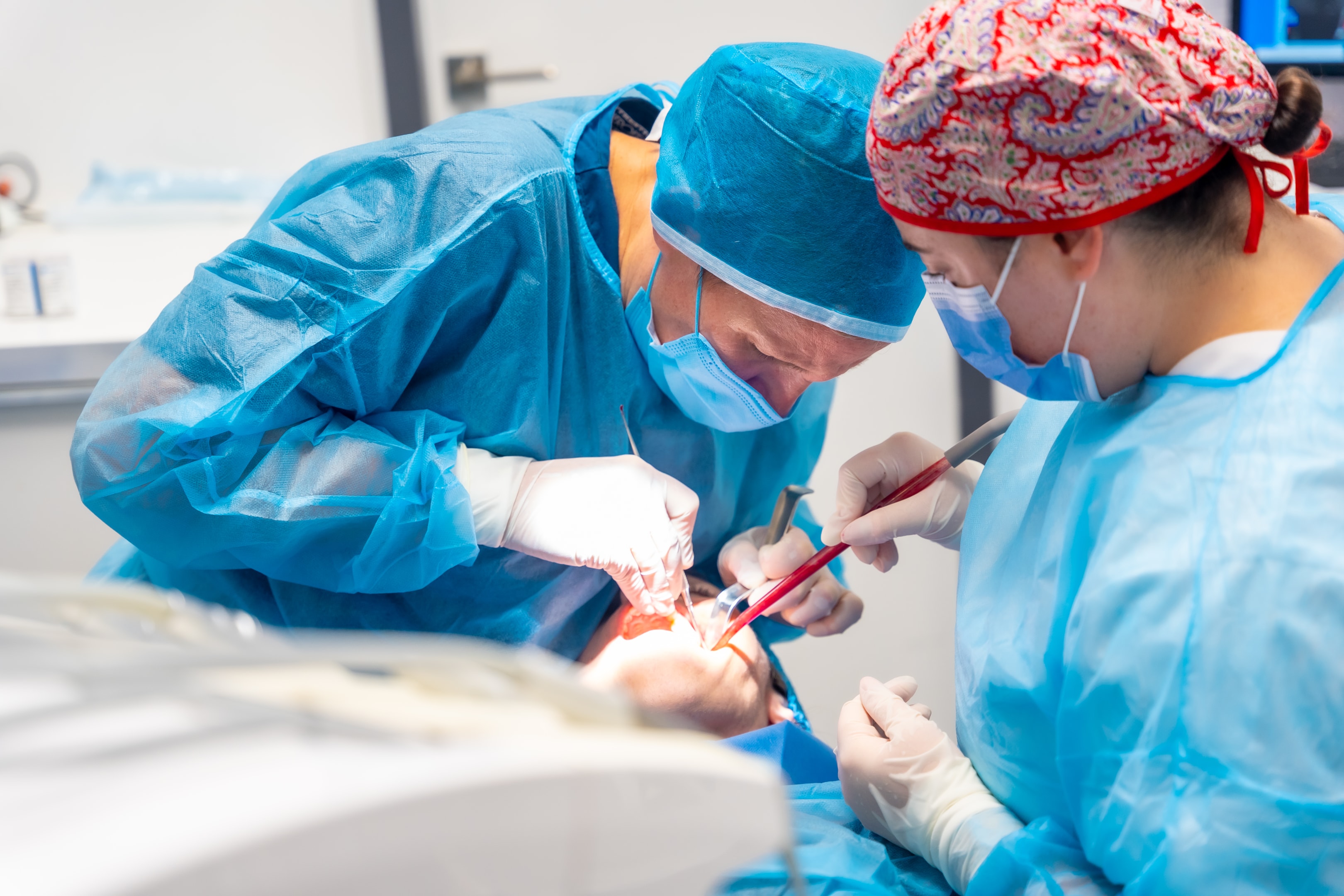 Oral surgeon performing oral and maxillofacial surgery in the operating room