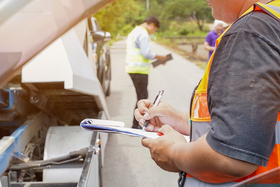 A person inspecting a car in a junkyard