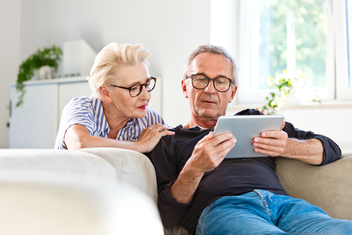 Mature couple looking with concern at a tablet. 