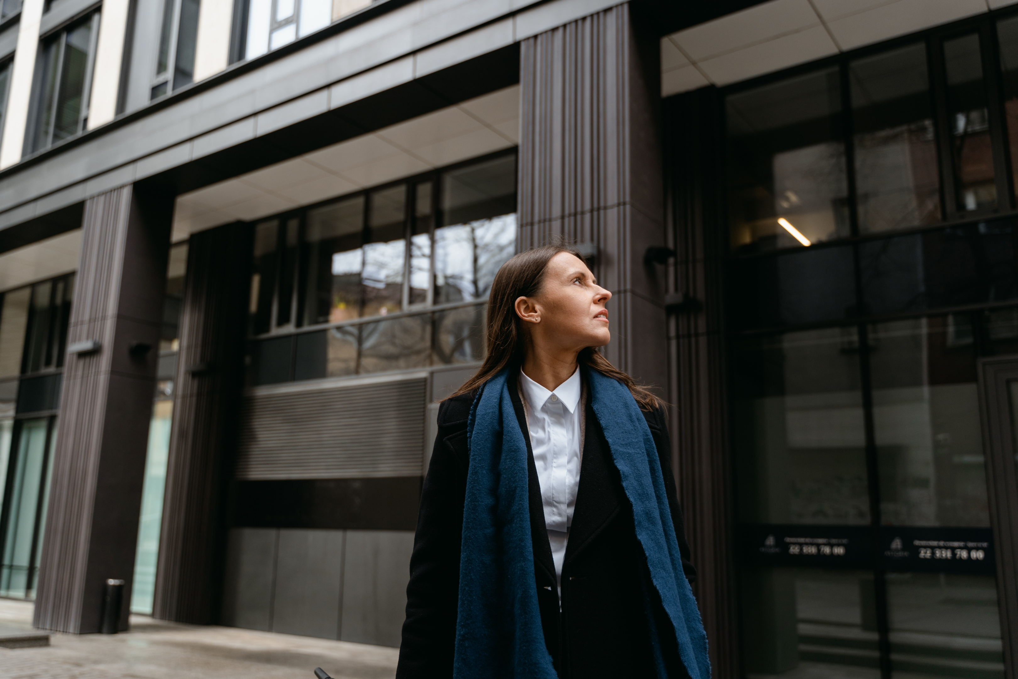 a woman looking up a building