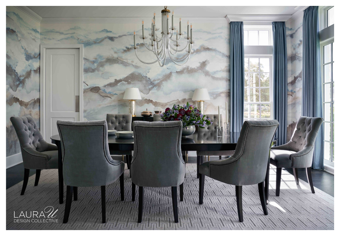 Dining room designed by Laura U Design Collective featuring Phillip Jeffries Beyond wallcovering in Blue Vista on White Paper Weave, blue drapery, gray upholstered dining chairs, black dining table, and a contemporary silver chandelier.