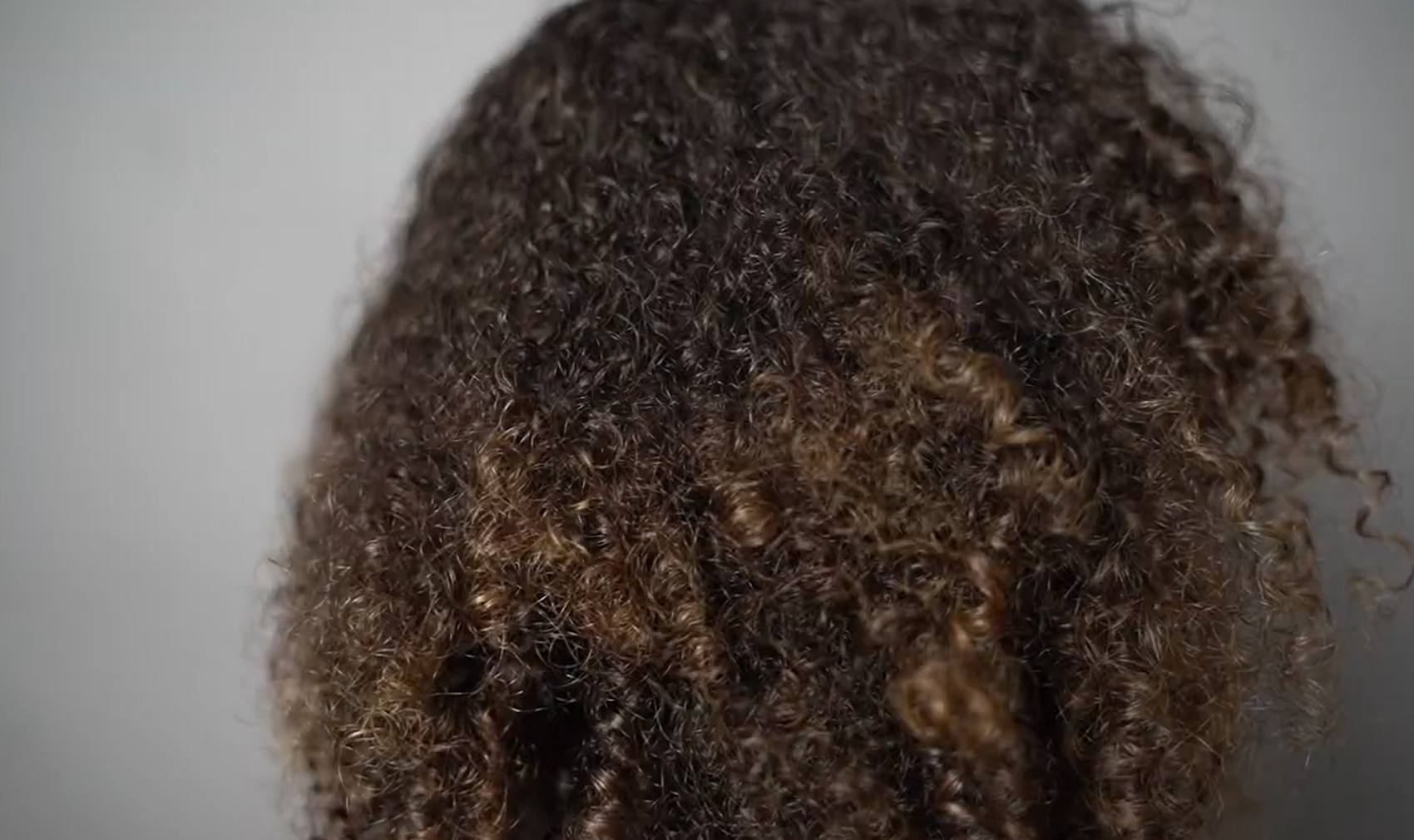 undefined hair with unruly strands of curly hair