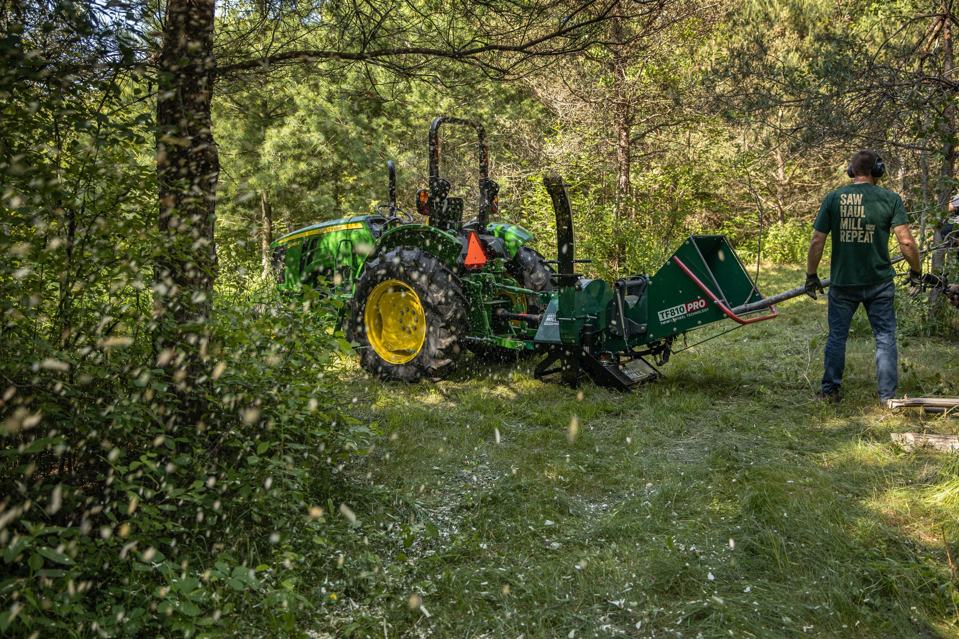 A man feeding branches into a Woodland Mills wood chipper. 