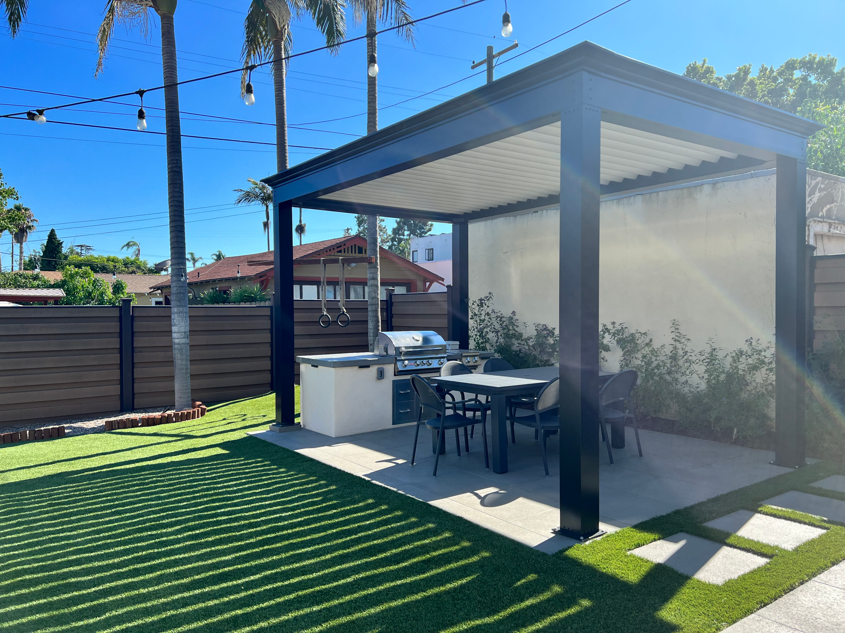 Outdoor kitchens with outdoor furniture and modern pergola granting shade cover from new pergola