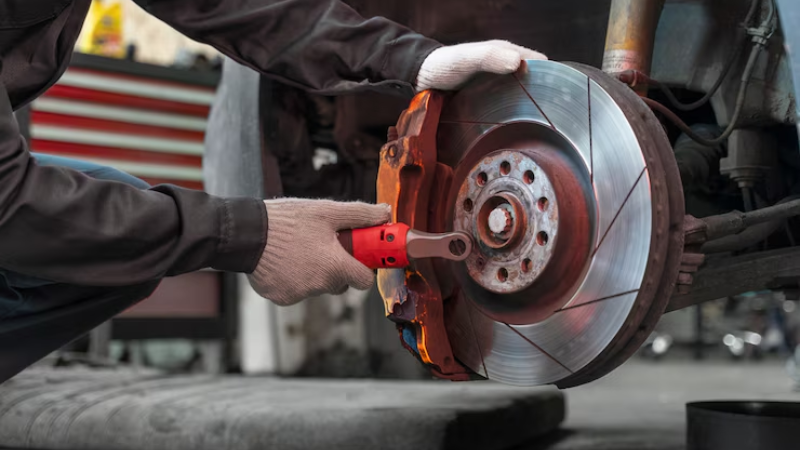 A mechanic is creating an on point customised car caliper wrap
