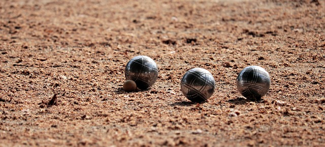 pallino and 3 bocce balls on a dirt court