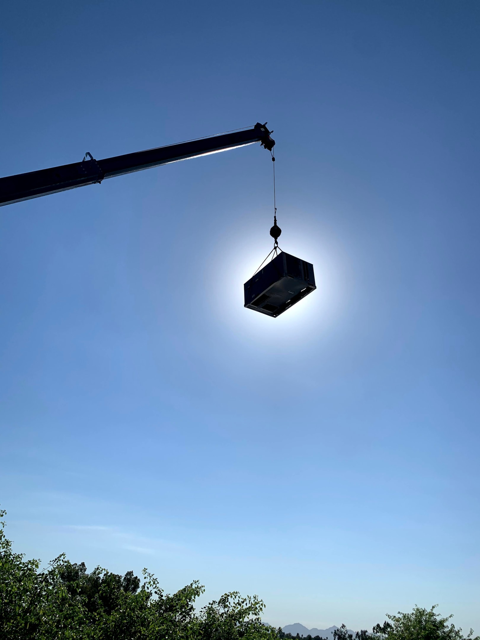 A professional HVAC technician is installing a new outdoor AC condenser unit, ensuring it is set up correctly for optimum cooling capacity. The technician is focused on connecting the condenser coils and checking the airflow to guarantee the air conditioning system will blow cool air efficiently.