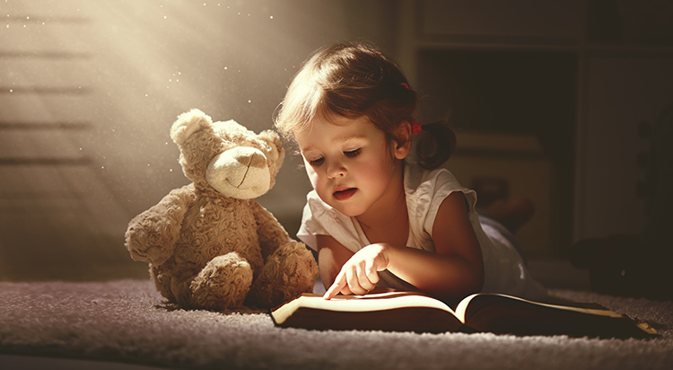Un enfant lit quelque chose à son doudou