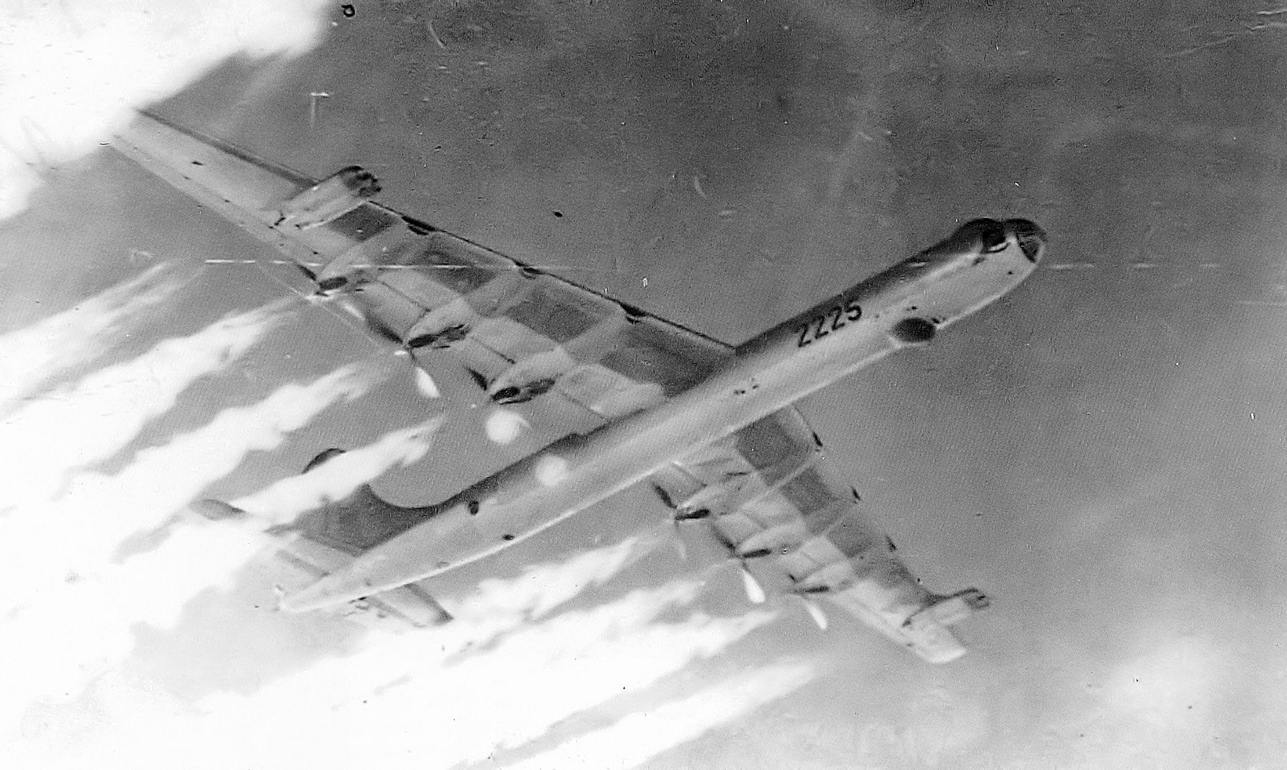 A B-36 bomber flying over a landscape.
