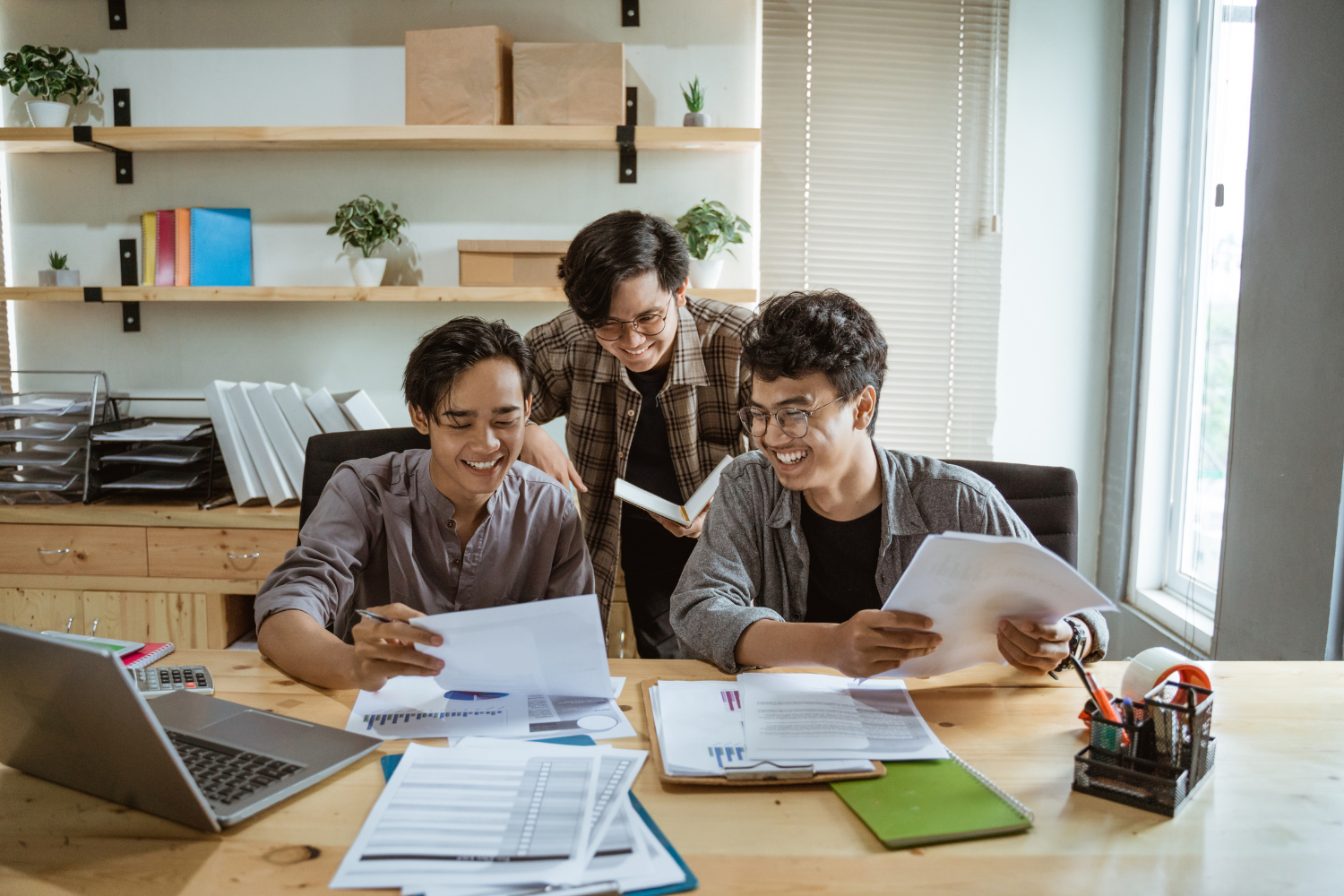 Filipino coworkers smiling and working together.