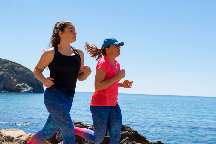 Two women running on the beach. 