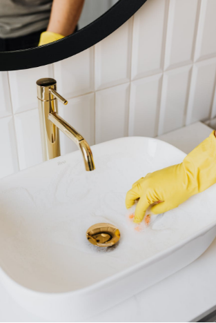 house cleaner in Dallas cleaning a sink