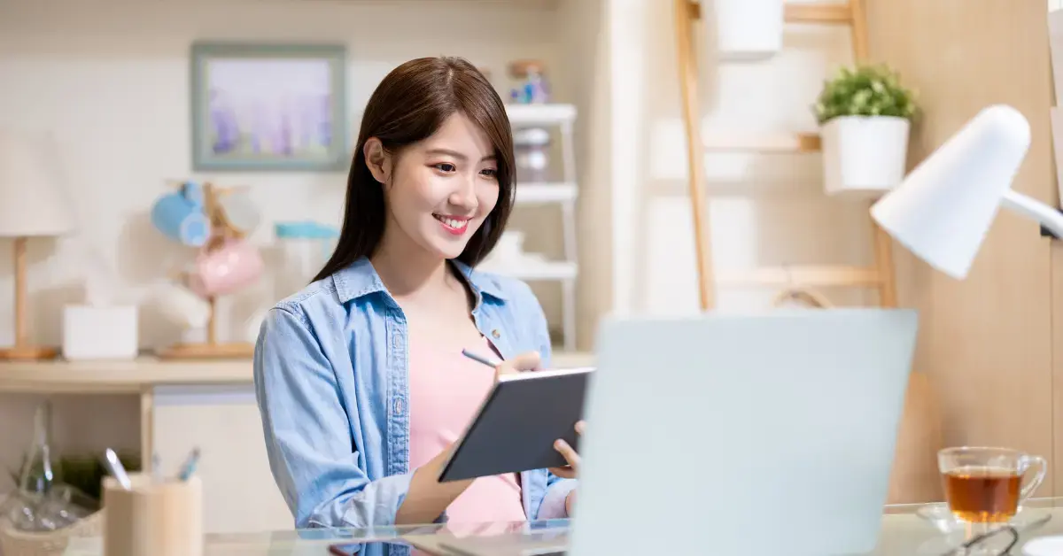 A woman filing back taxes electronically using a digital tablet and laptop in her home office.