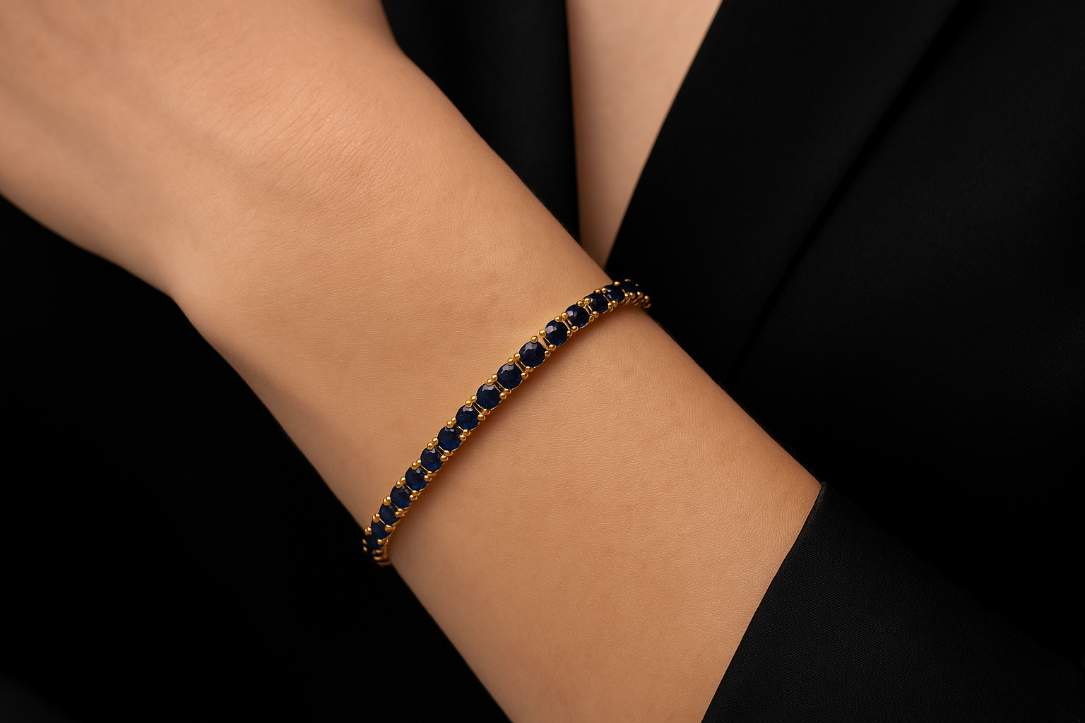 Geltono aukso tennis apyrankė su mėlynais safyrais ant moters riešo