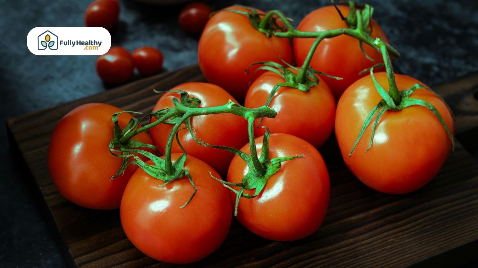 Whole cherry tomatoes on a dark wooden board with background blur