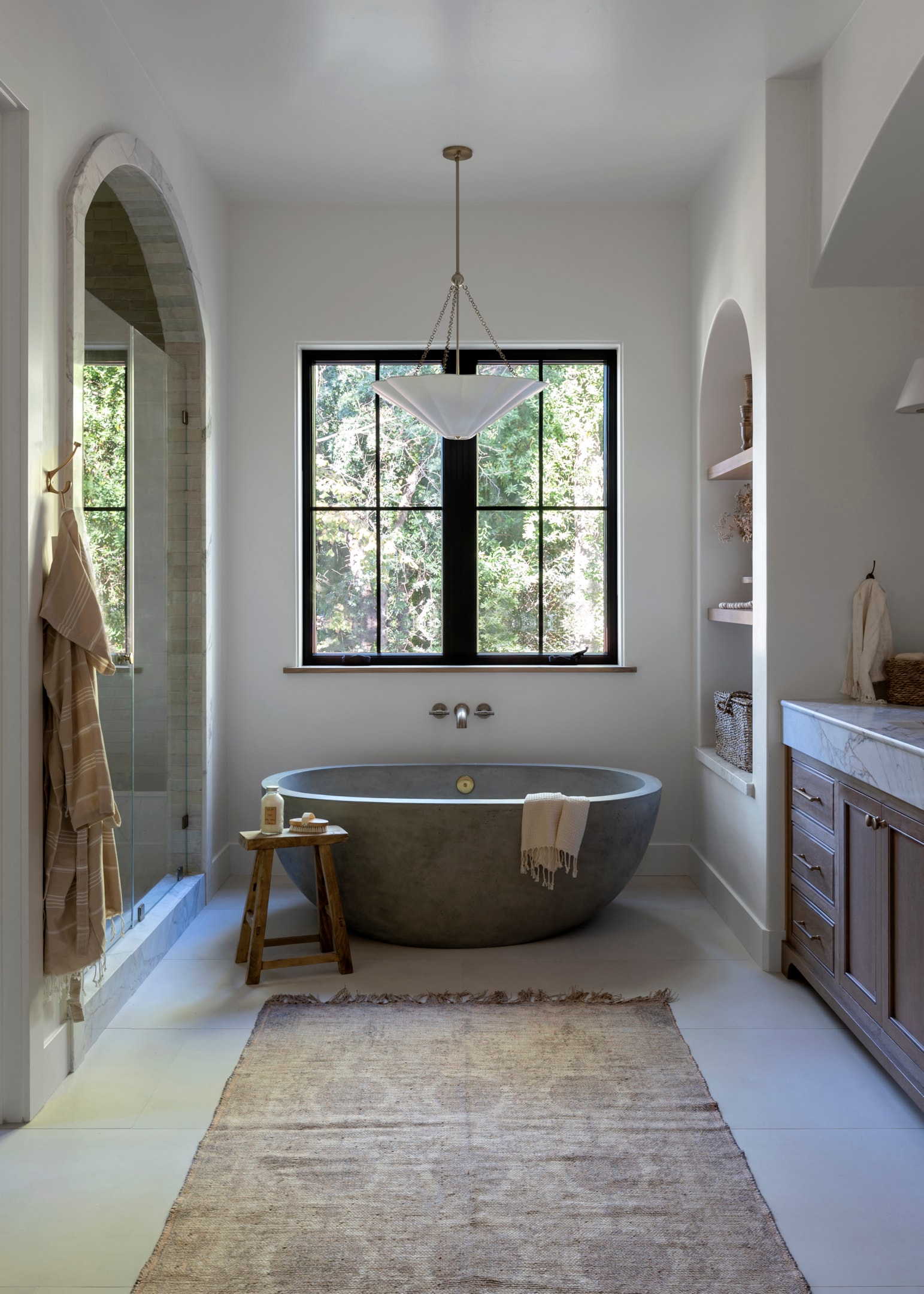 Serene bathroom with a concrete bathtub, large window, and Alana 3-Light Pendant ceiling light, adding a soft, elegant glow to the minimalist design.