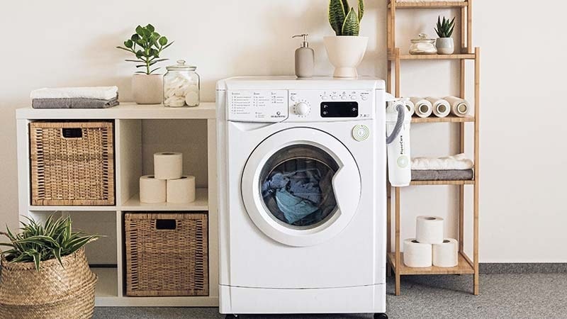 A white washing machine in the laundry room