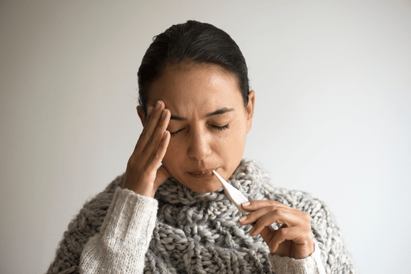 a woman with a fever who should reach out to her surgeon from complications from tooth extraction