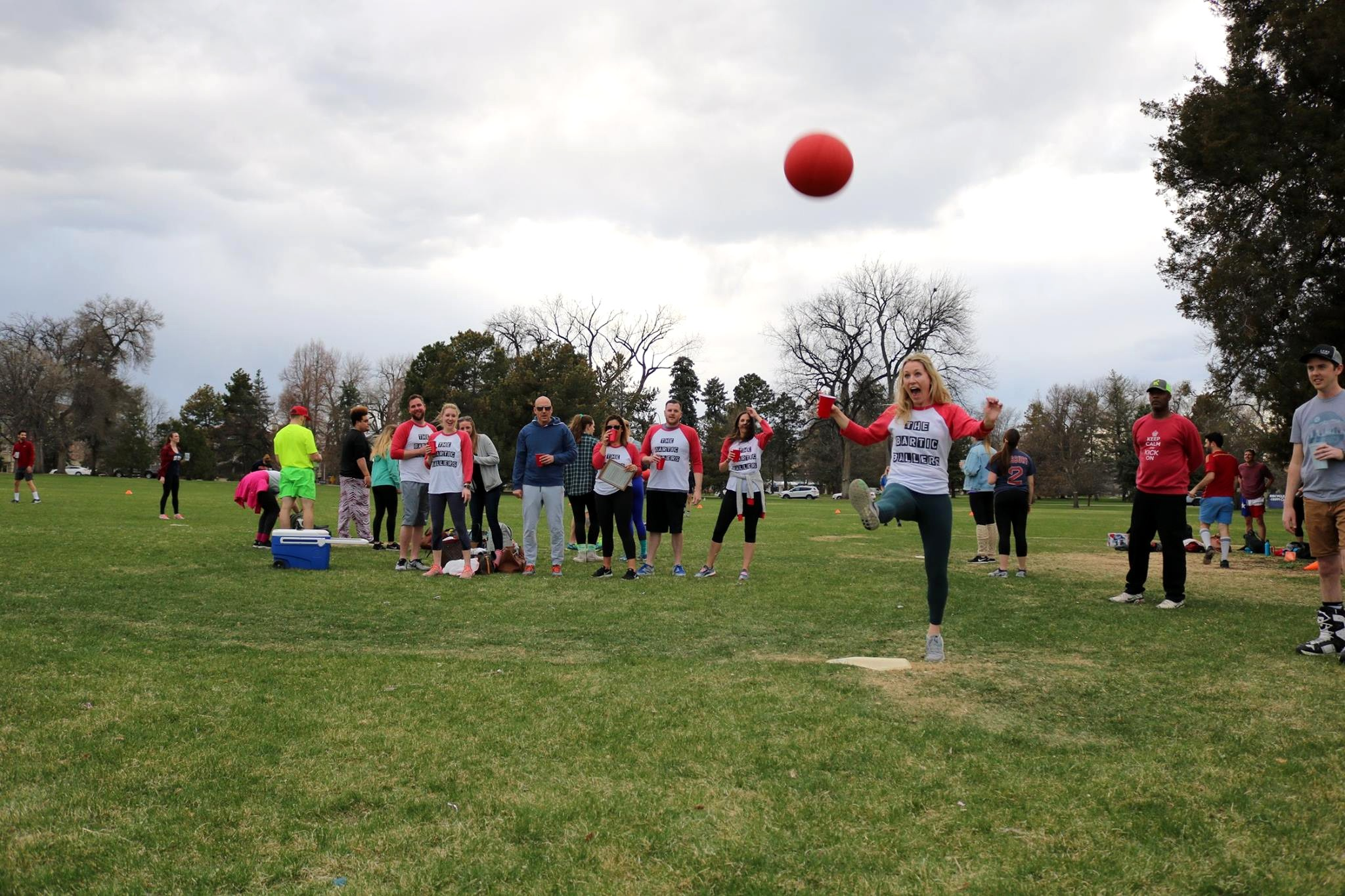 A woman participating in a Denver cup-in-hand kickball game 