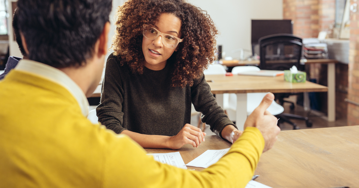 An accountant reviewing financial records with a client while explaining what are payroll liabilities and OnlyFans tax obligations on a laptop.