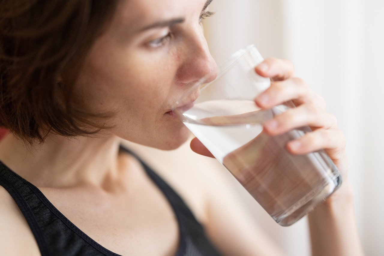 An image of a woman drinking a glass of water. 