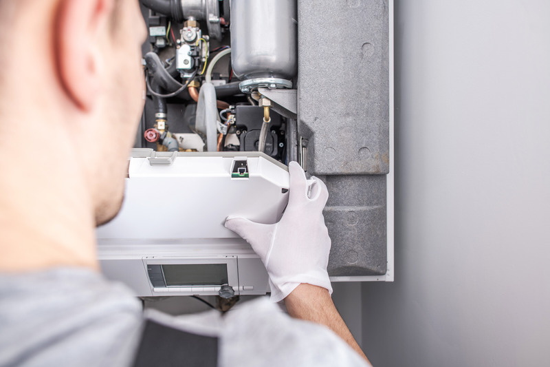 Installateur führt eine Thermenwartung durch.