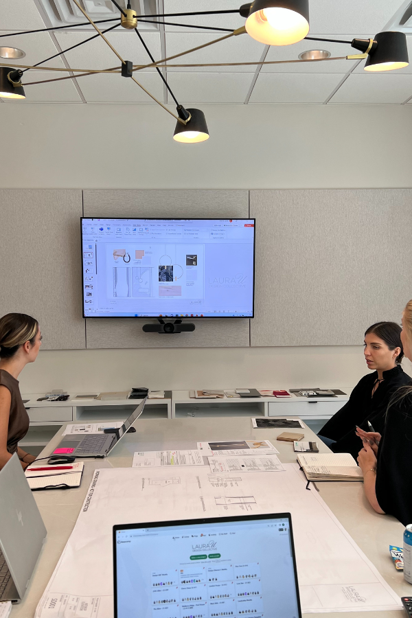 Interior design team reviewing drawings and material selections during a studio meeting.