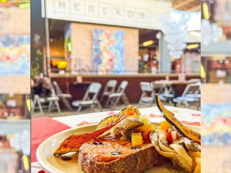 Bruschetta em prato sobre a mesa e balcão do Magri Café ao fundo. Imagem: Reprodução Instagram.