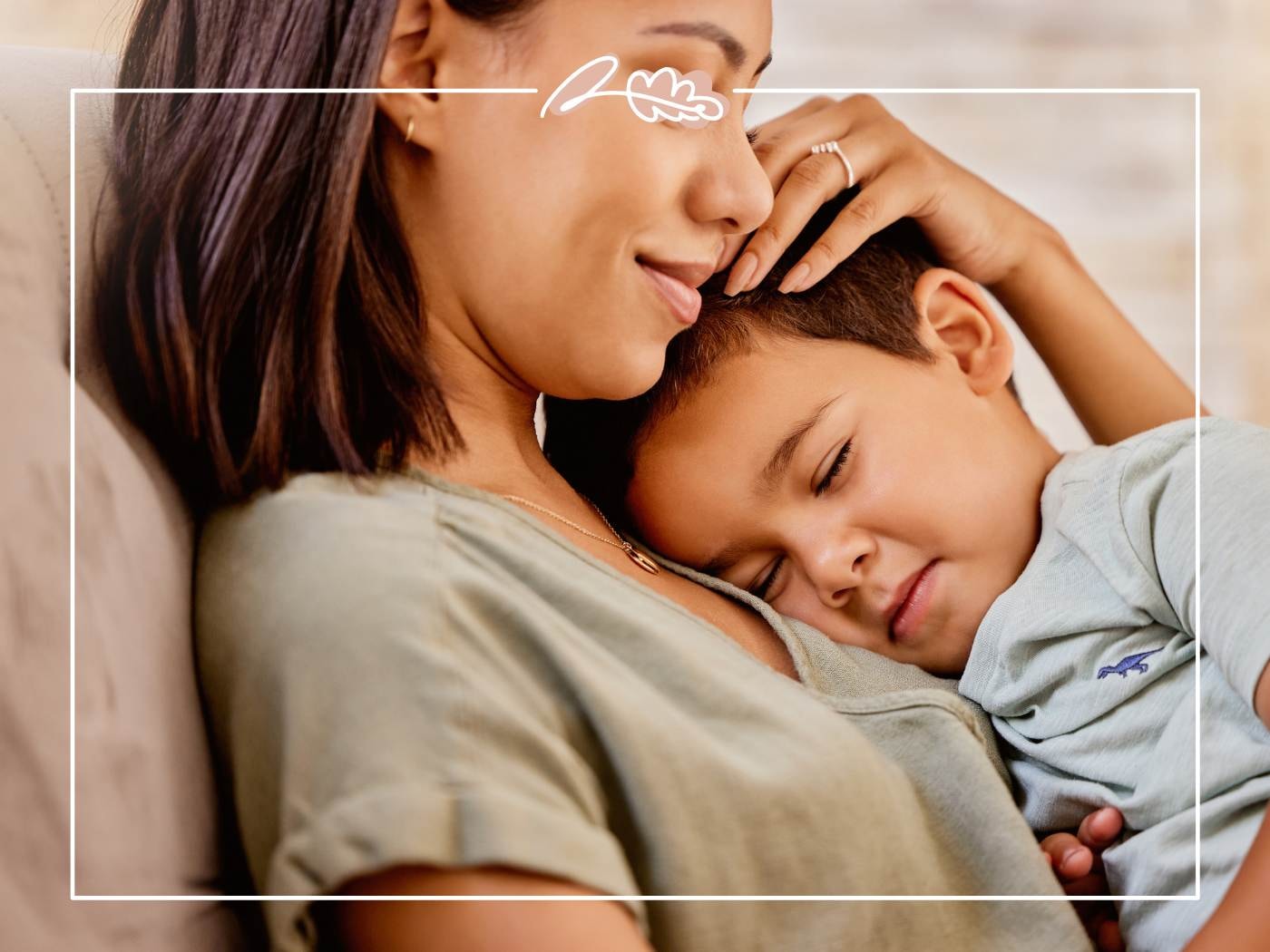 Mum cradling her young child on the sofa, expressing a deep, loving Mother’s Day connection.