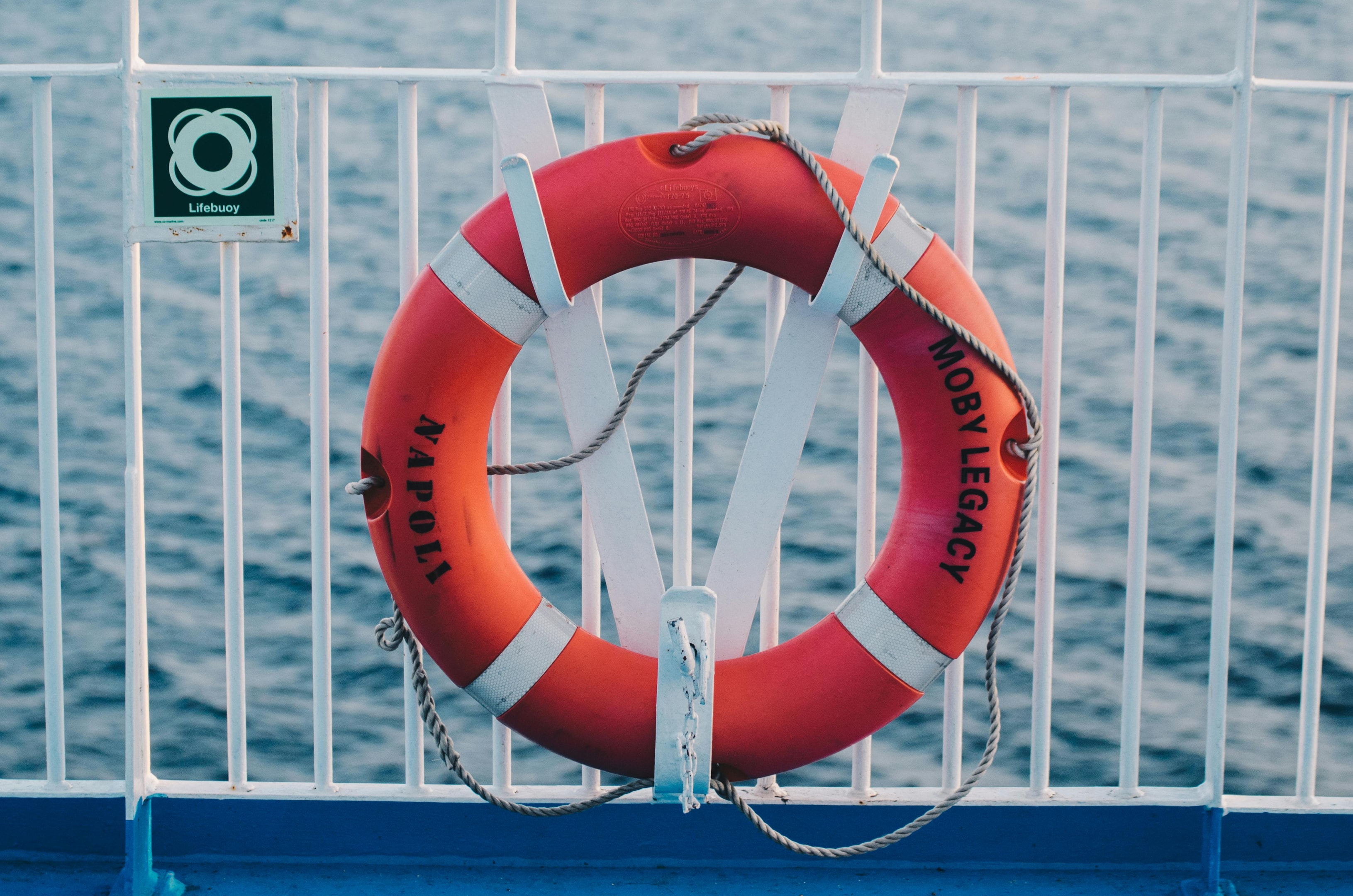 A round ring shaped lifebuoy secured to the railing.