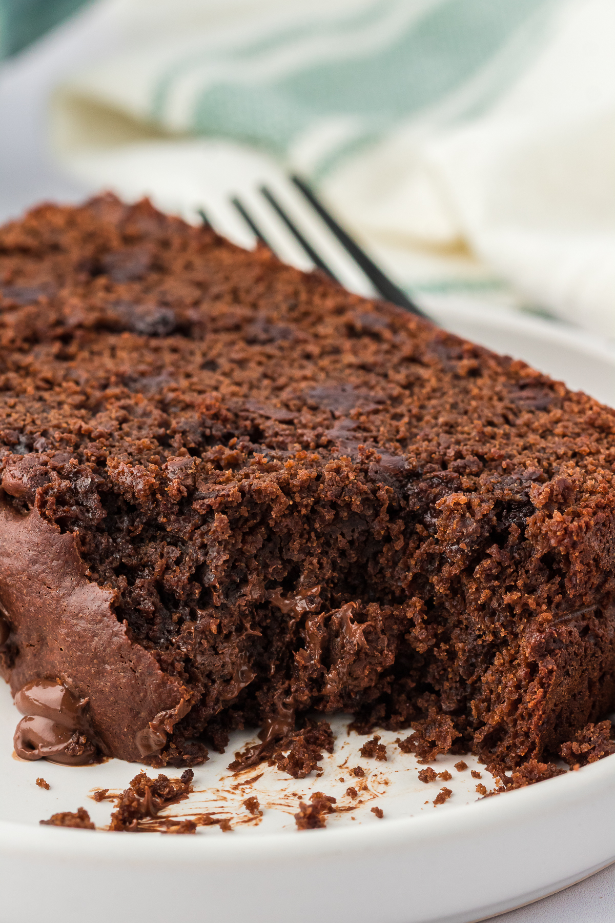 slice of chocolate loaf cake on a plate with a bite missing